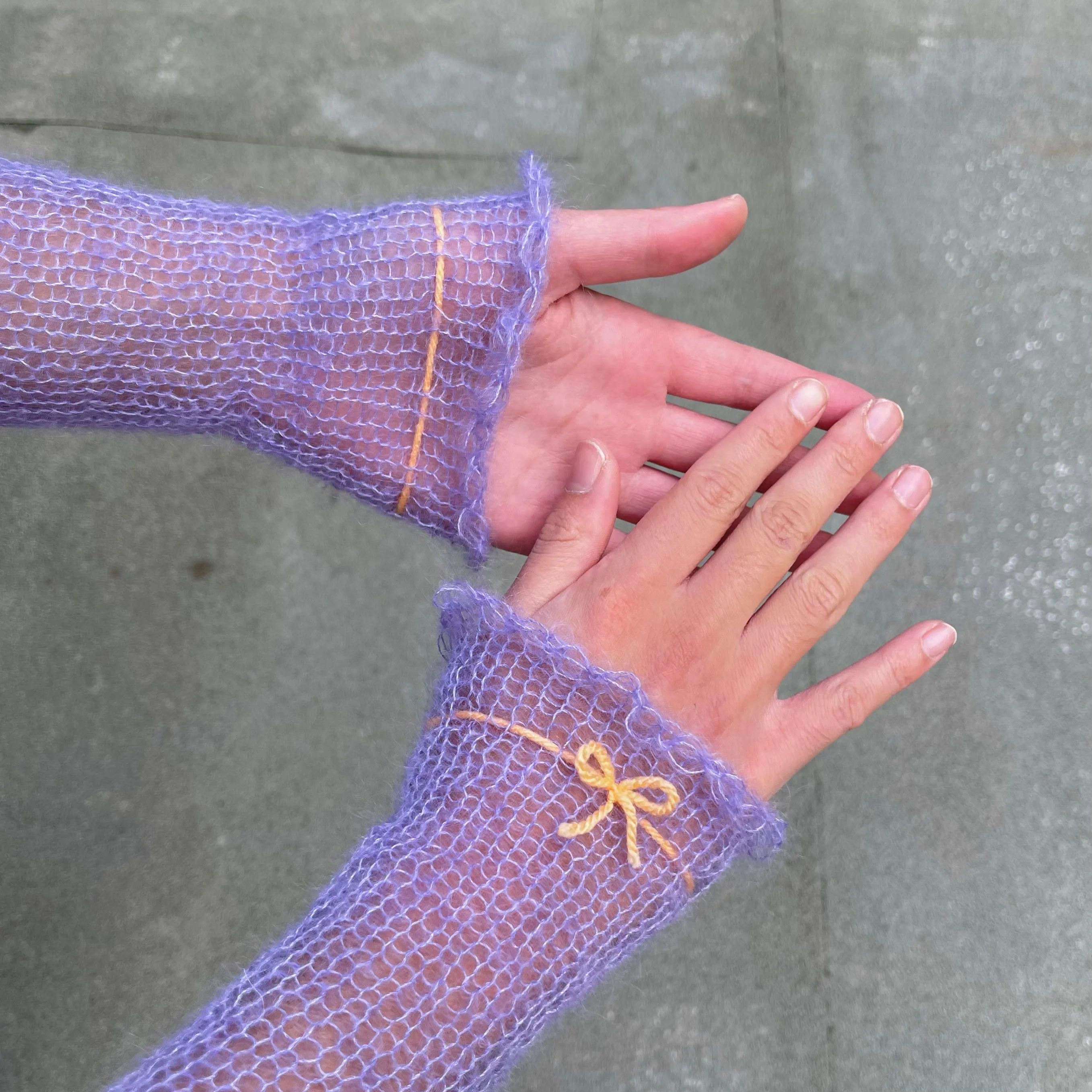 Handmade knitted mohair hand warmers in periwinkle with pastel orange bow