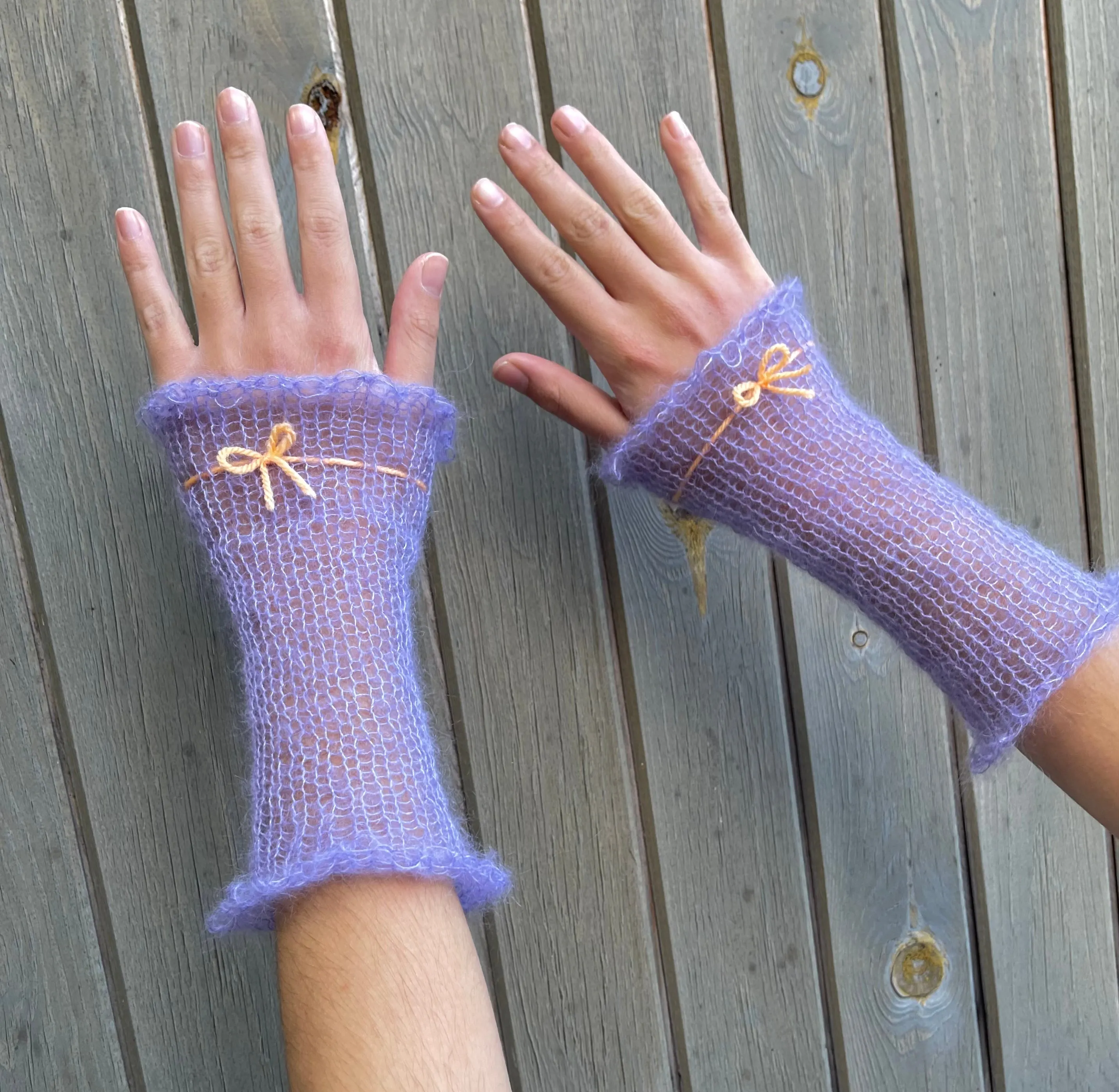 Handmade knitted mohair hand warmers in periwinkle with pastel orange bow