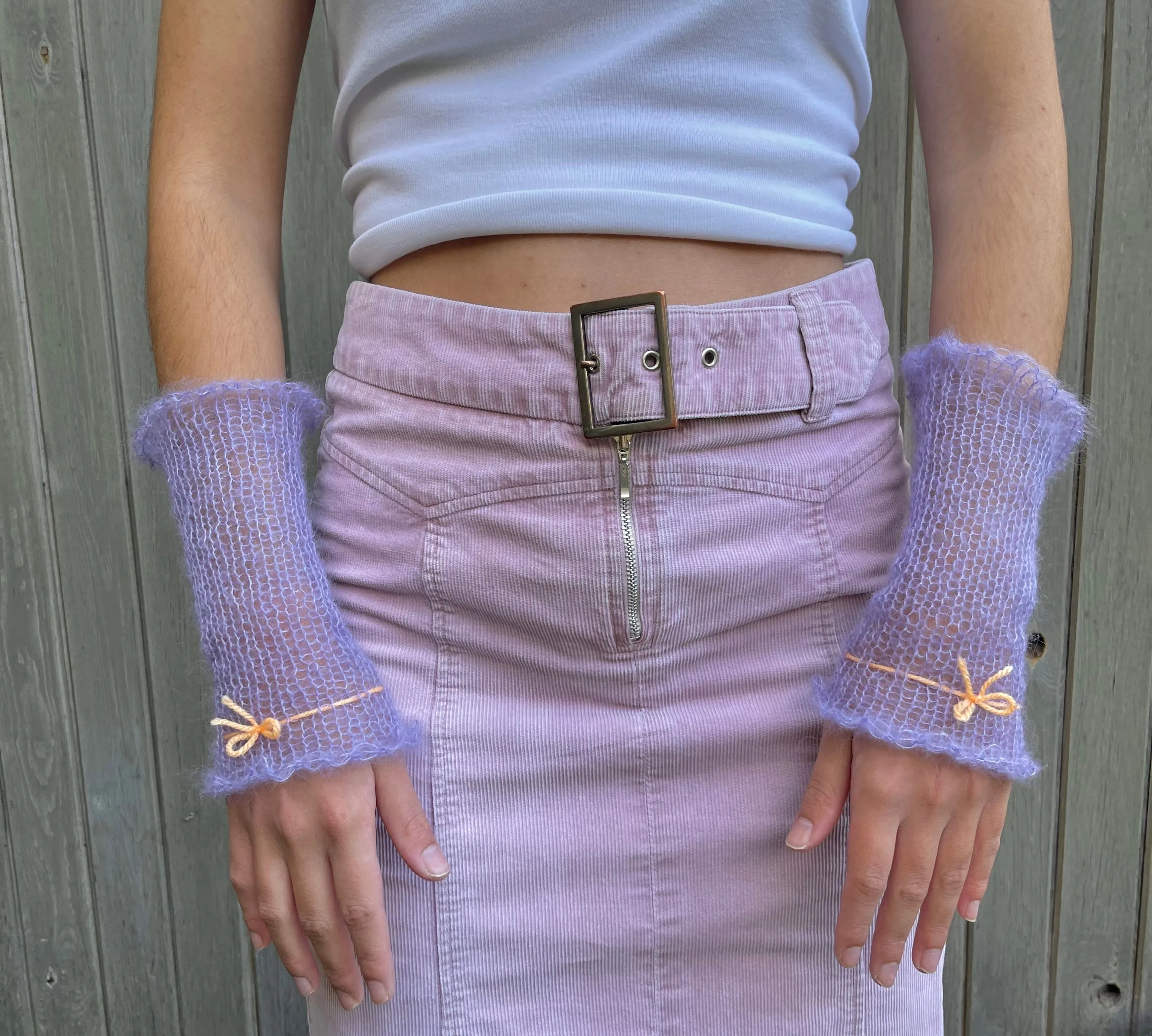 Handmade knitted mohair hand warmers in periwinkle with pastel orange bow