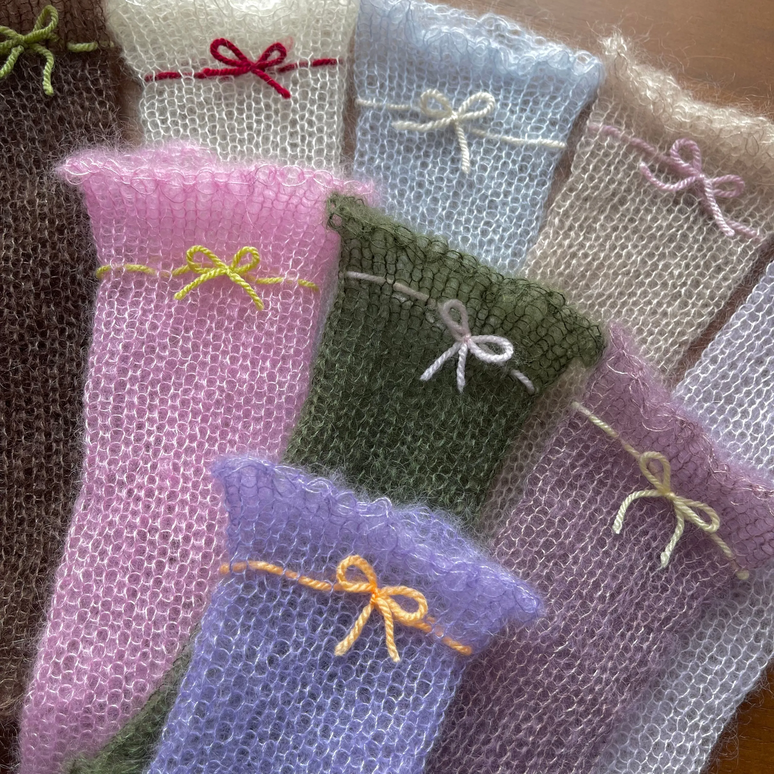 Handmade knitted mohair hand warmers in periwinkle with pastel orange bow